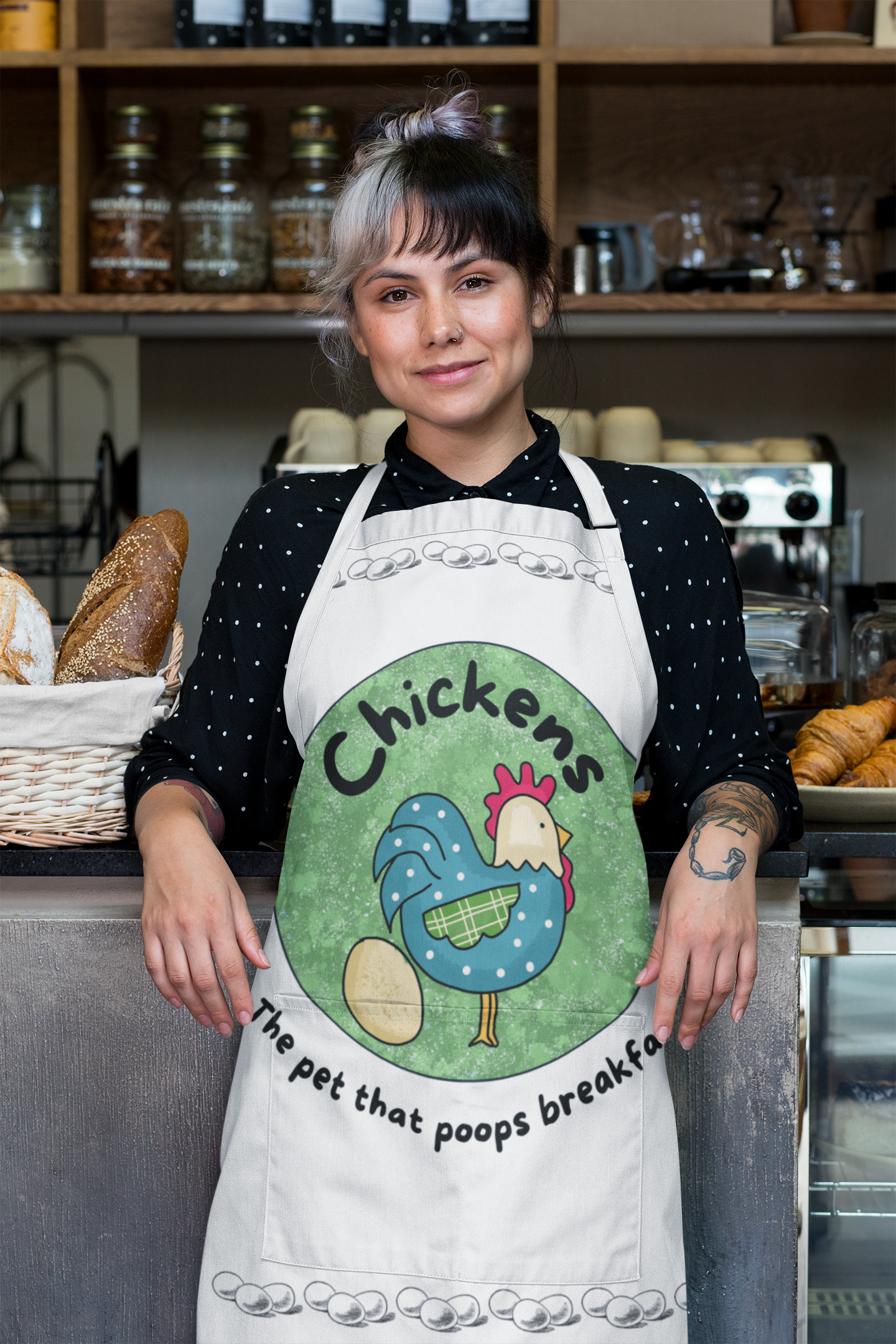 women wearing and apron that says "chickens the pet that poops breakfast"